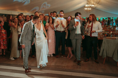 Wedding guests dancing and celebrating in marquee.