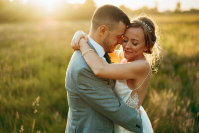 Couple embracing in sunset meadow.