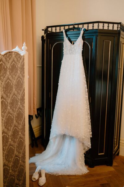 Elegant white wedding dress hung on wardrobe