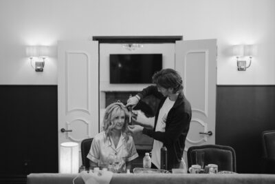 Hairstylist curling woman's hair in salon