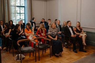 People seated at a formal event, smiling.