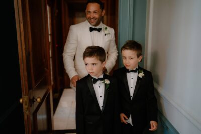 Smiling man and two boys in tuxedos