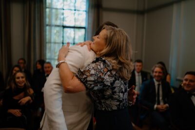 Woman hugging man at social gathering.