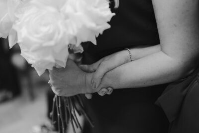 Close-up of hands holding bouquet tightly.
