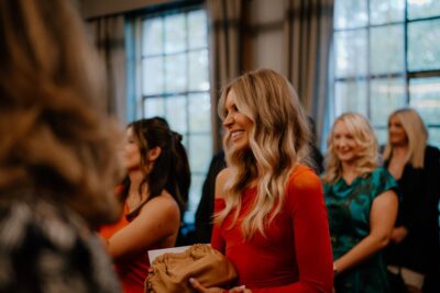 Women gathering at formal event, smiling