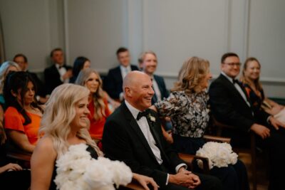 Guests smiling at indoor wedding ceremony