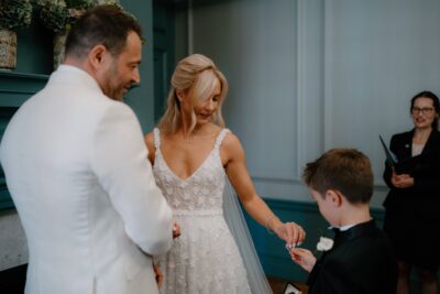 Bride receiving ring from young boy