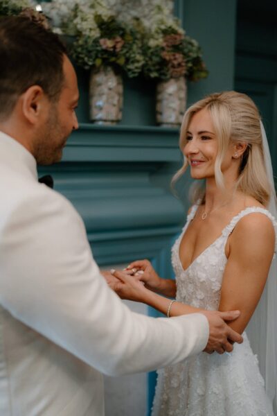 Couple exchanging rings during wedding ceremony.