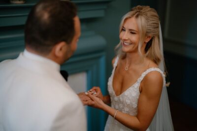 Bride exchanging rings with groom at wedding