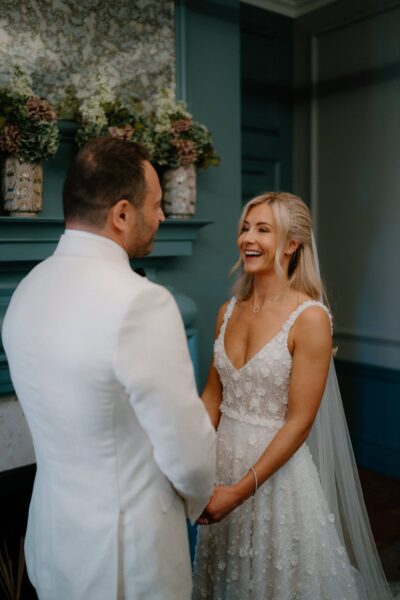 Bride and groom smiling during wedding ceremony.