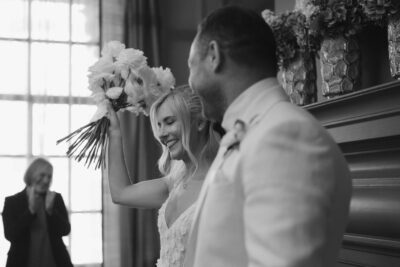 Bride smiling holding bouquet in wedding ceremony