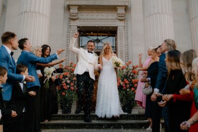 Bride and groom exit with confetti celebration.