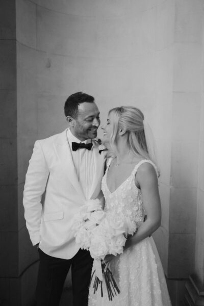 Happy couple on wedding day smiling warmly.