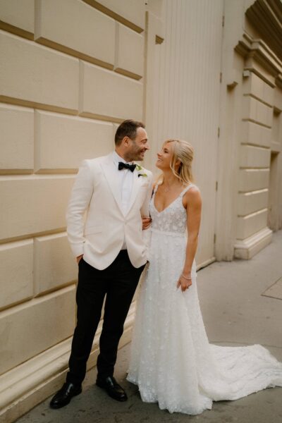 Bride and groom smiling outside building