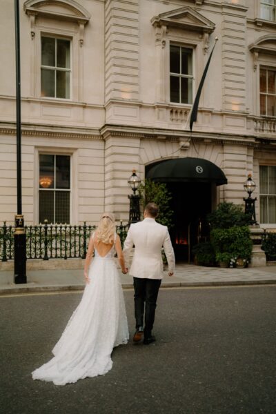 Bride and groom walking to hotel entrance.