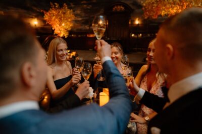 Group celebrating with champagne toasts indoors.