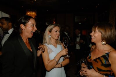 People laughing and chatting at a formal event.