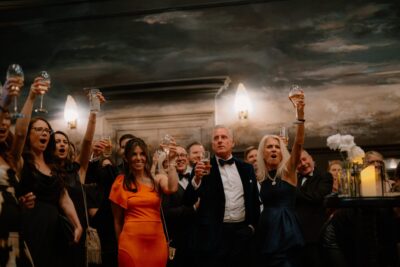 Group celebrating and raising glasses indoors.