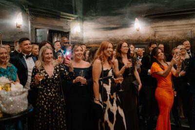 Guests in formal attire at an elegant gathering.