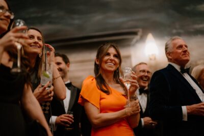 Group celebrating with drinks, wearing formal attire.