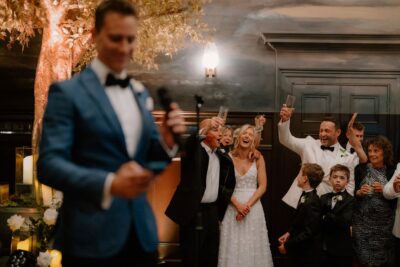 Wedding guests raising glasses in celebration.