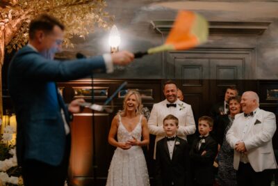 Couple laughing during wedding speech indoors.