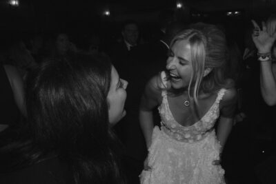 Two women laughing at a lively party