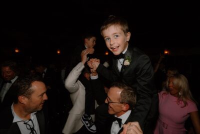 Smiling boy on shoulders at lively party