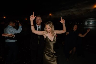 People dancing energetically at a dimly lit party.