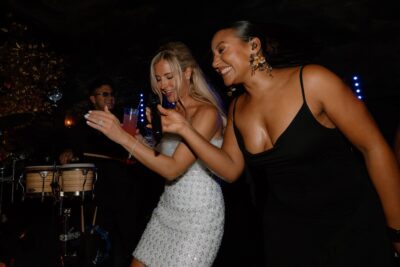 Women dancing and singing at a party.