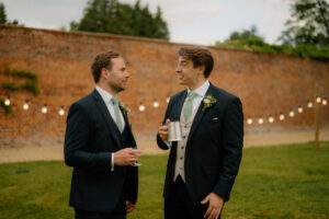 Two men in suits talking outside at event.