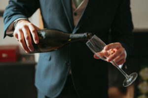 Pouring champagne into glass at event.