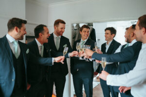 Groomsmen toasting with champagne in suits.