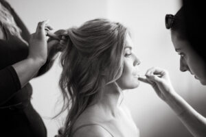 Bridal makeup and hair styling session in progress.