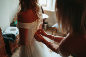 Bride getting dressed, wedding preparation moment.