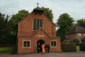 People outside a traditional brick church building.