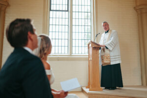 Officiant speaking at wedding ceremony in church.