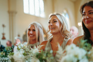 Guests smiling at wedding ceremony in church