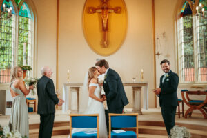 Wedding ceremony kiss inside a church.