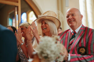 Guests clapping at a joyful church ceremony.