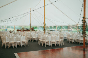 Elegant marquee wedding reception setup with string lights.