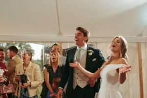 Joyful wedding reception with laughing bride and groom.