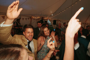 Guests dancing at a lively wedding reception.
