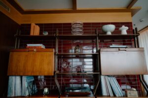 Vintage wooden shelving with vinyl records and books.