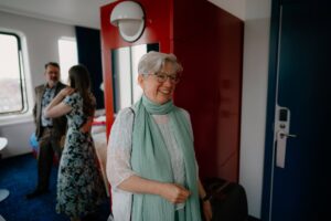 Smiling woman in a scarf inside a room.
