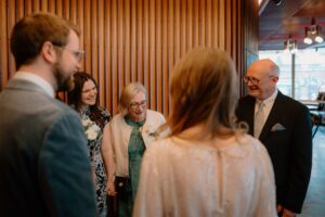 Group of people smiling and chatting indoors.