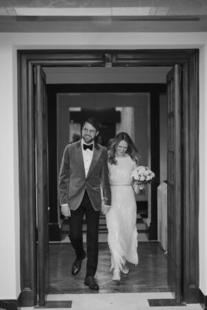 Happy couple walking hand in hand indoors.