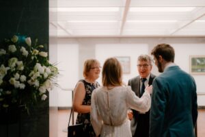 People chatting at a formal event.