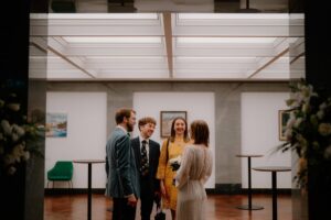 People chatting at indoor event, formal setting.
