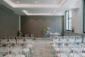 Empty wedding ceremony room with chairs and flowers.
